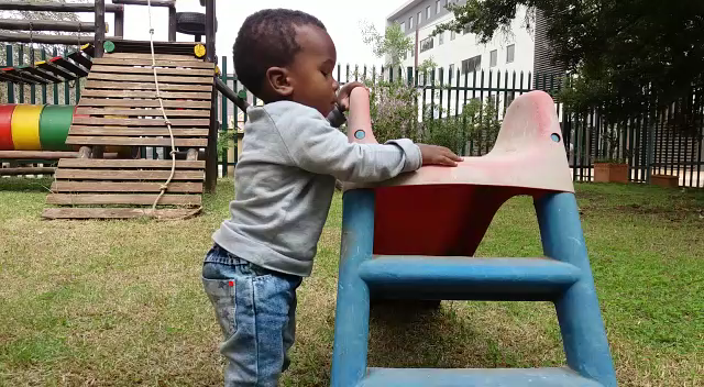 2 Year old blind toddler playing on a slide