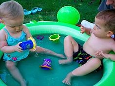 Little blind boy playing with water toys in a plastic pool together with another child