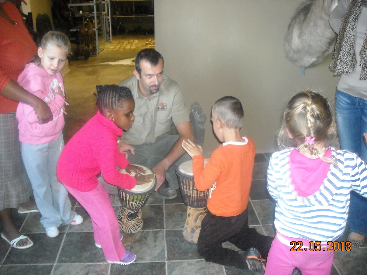 2 children playing on an africa drum