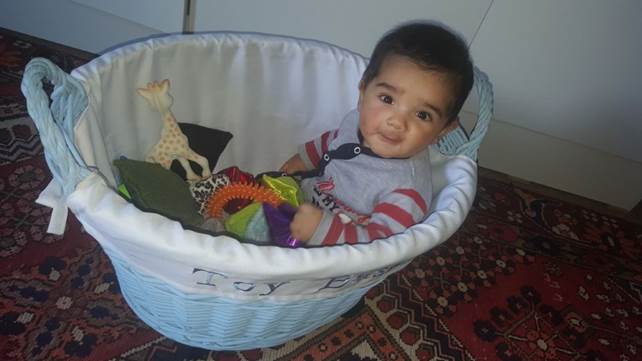 child in a basket of toys