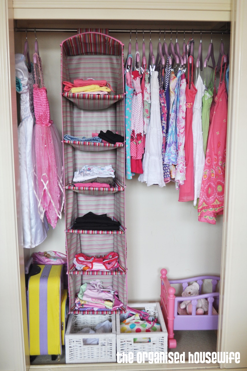 girls cupboard with clothes hanging with camping shelf