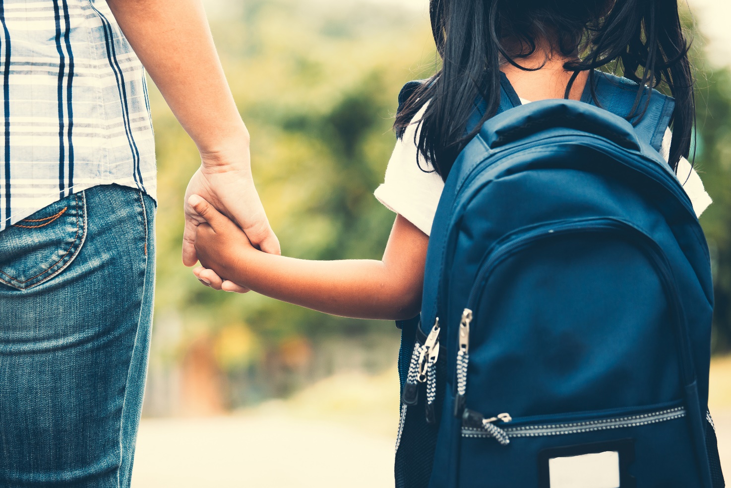 rear view of person wearing jeans and child wearing a back pack