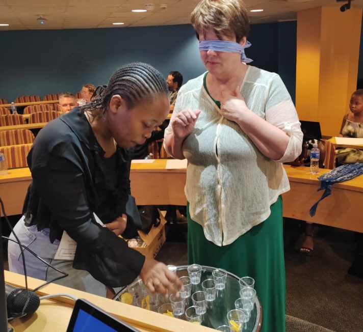 Londiwe at assisting an attendee to taste various flavous